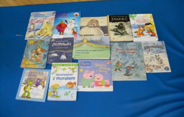 Książki o tematyce zimowej przygotowane przez bibliotekarza na zajęcia z dziećmi