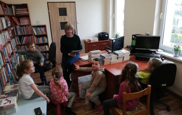 Bibliotekarka podczas czytania dzieciom książki