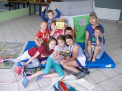 K. Szczygieł i grupa dzieci uczestniczących w wakacyjnych warsztatach