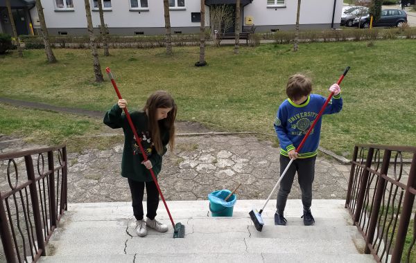 Dwoje dzieci sprzątających teren wokół Biblioteki