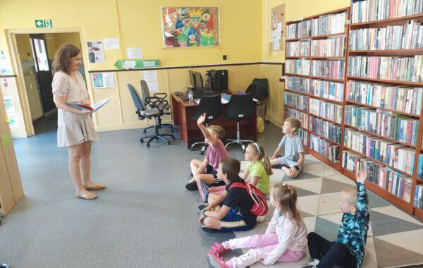 Bibliotekarka oraz dzieci biorące udział w zajęciach