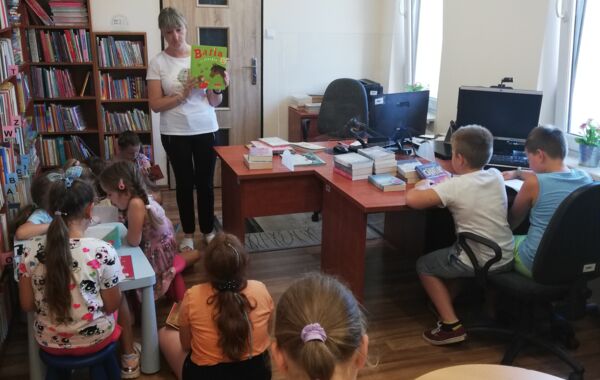 Bibliotekarz pokazuje książkę grupie dzieci