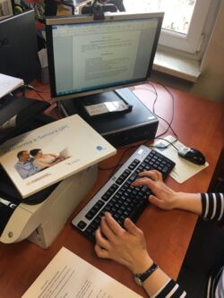 Pracownik filii podczas przygotowań do kursu z obsługi komputera