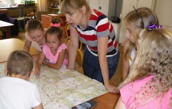 Katarzyna Szczygieł pokazuje dzieciom mapę Polski podczas lekcji bibliotecznej