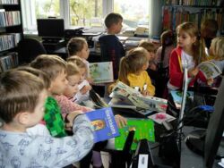 Uczestnicy spotkania oglądają przygotowane książki dla małych czytelników