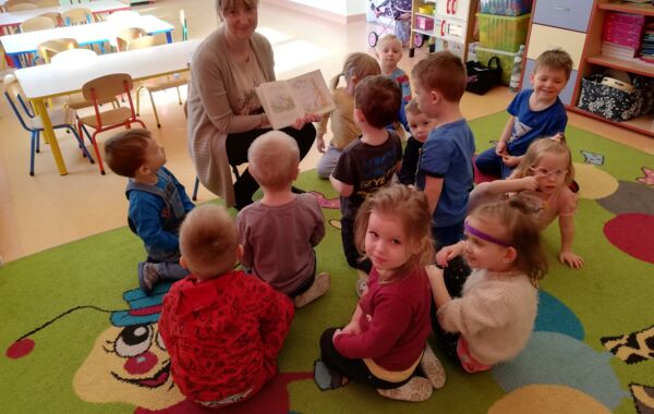 Bibliotekarka pokazująca przedszkolakom ilustracje z czytanej książki