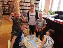 Pracownik filii wraz z dziećmi biorącymi udział w zajęciach wakacyjnych w Domu Kultury w Myślachowicach