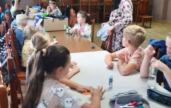 Dzieci siedzące przy stołach