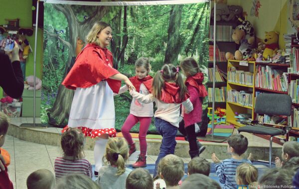 Aktorka grająca Czerwonego Kapturka w tańcu z trójką dzieci