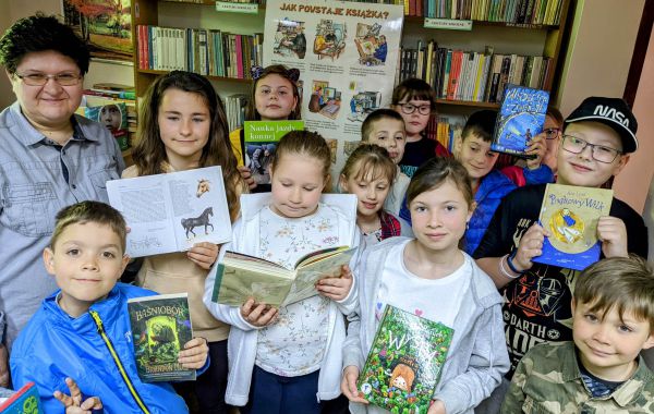 Bibliotekarz oraz dzieci biorące udział w lekcji bibliotecznej