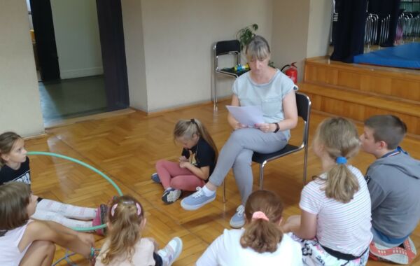 Bibliotekarka czytająca dzieciom biorącym udział w zajęciach