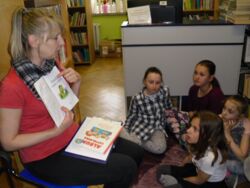 K. Szczygieł prezentuje książkę dzieciom w trakcie lekcji bibliotecznej