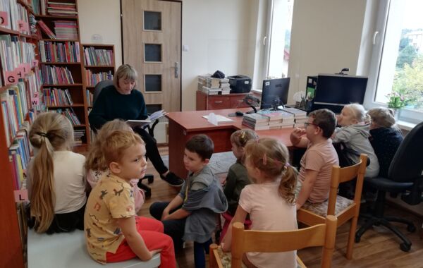 Bibliotekarz podczas czytania książki grupie dzieci
