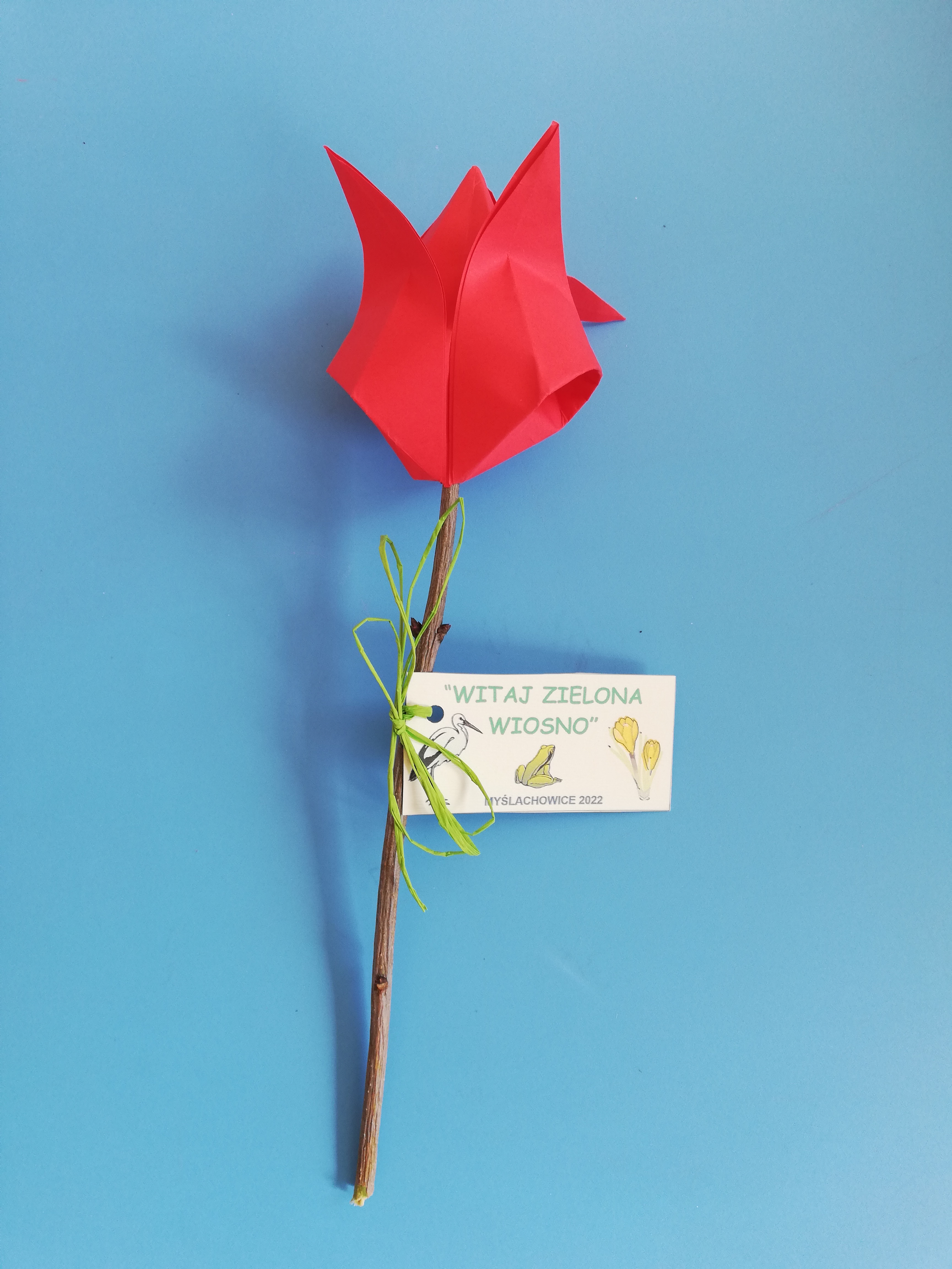 Papierowy kwiatek z zawieszką z napisem „Witaj Zielona Wiosno”